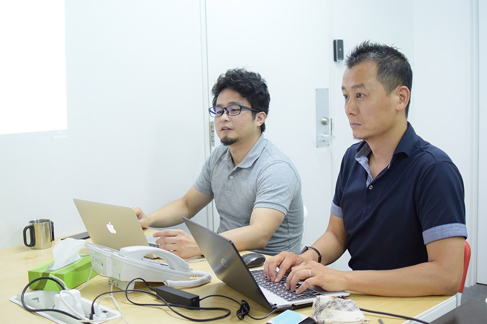 写真：Autosegmentについて質問する弊社代表・深田とFEの馴松